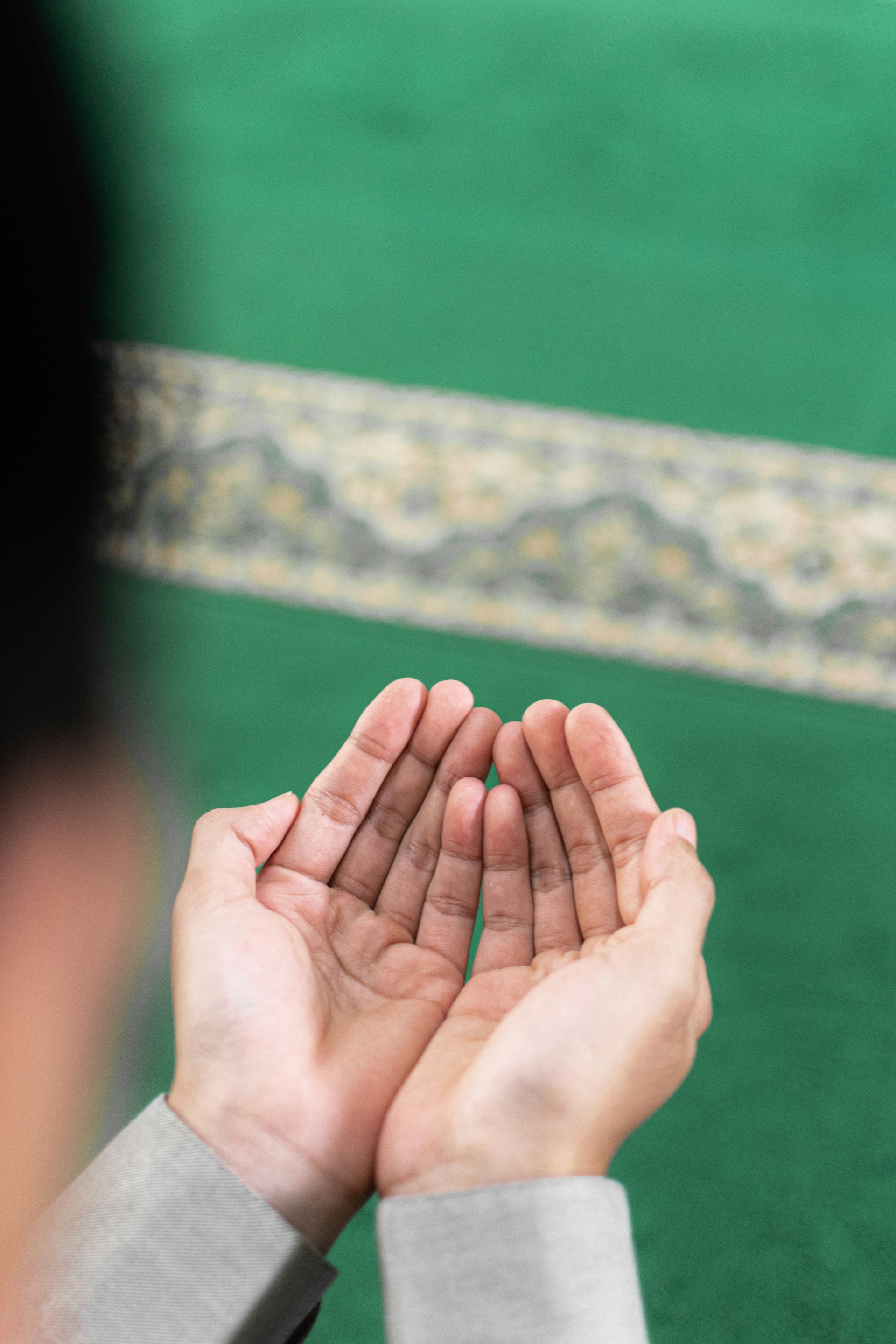 Tangan menengadah berdoa di atas sajadah